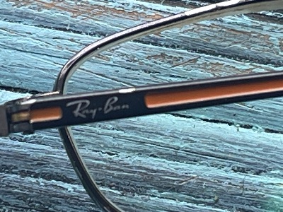 Ray-Ban black sunglasses with orange temple accents
